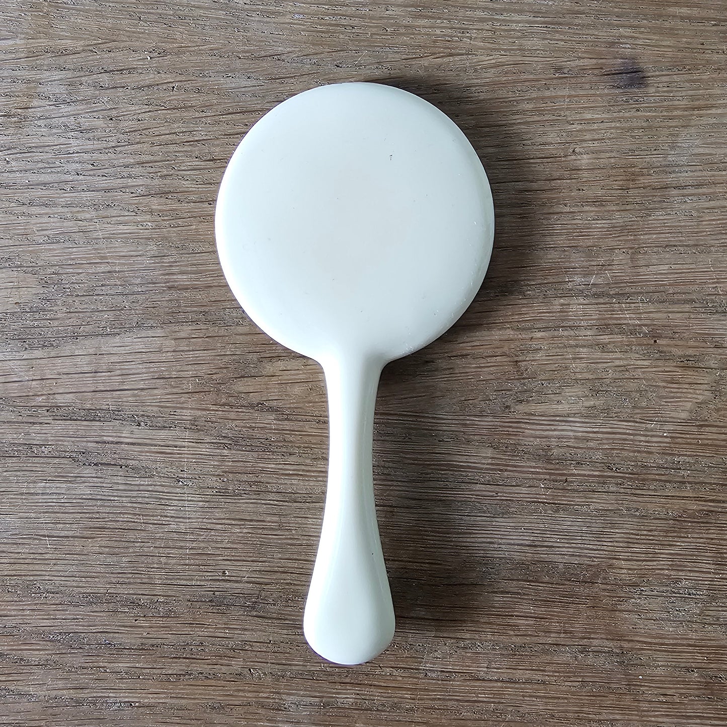 1960s cream plastic vanity hand mirror with shell detail handle