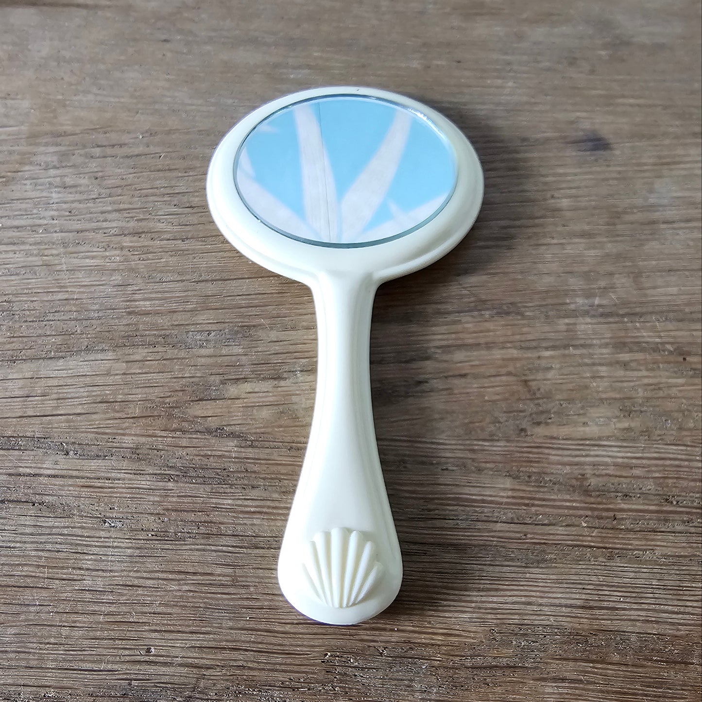 1960s cream plastic vanity hand mirror with shell detail handle