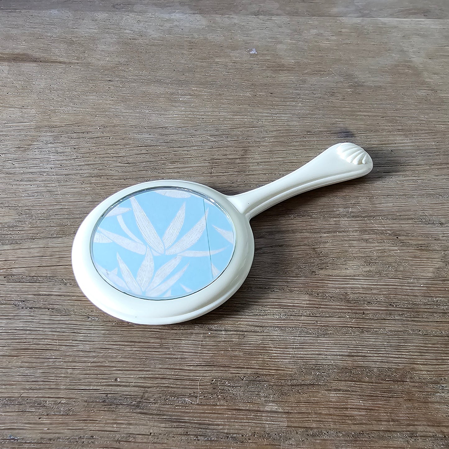 1960s cream plastic vanity hand mirror with shell detail handle
