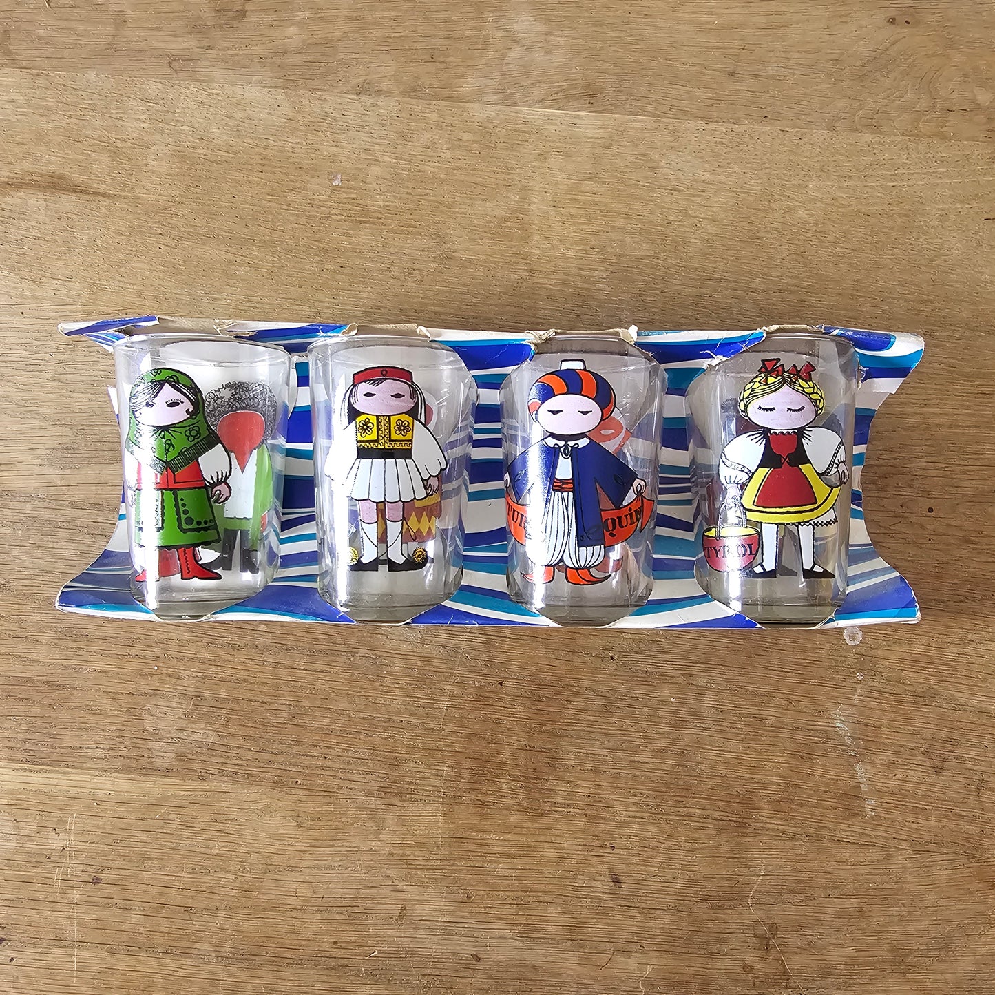 Set of four 1960s Saint-Gobain “World Doll” character tumblers with original box