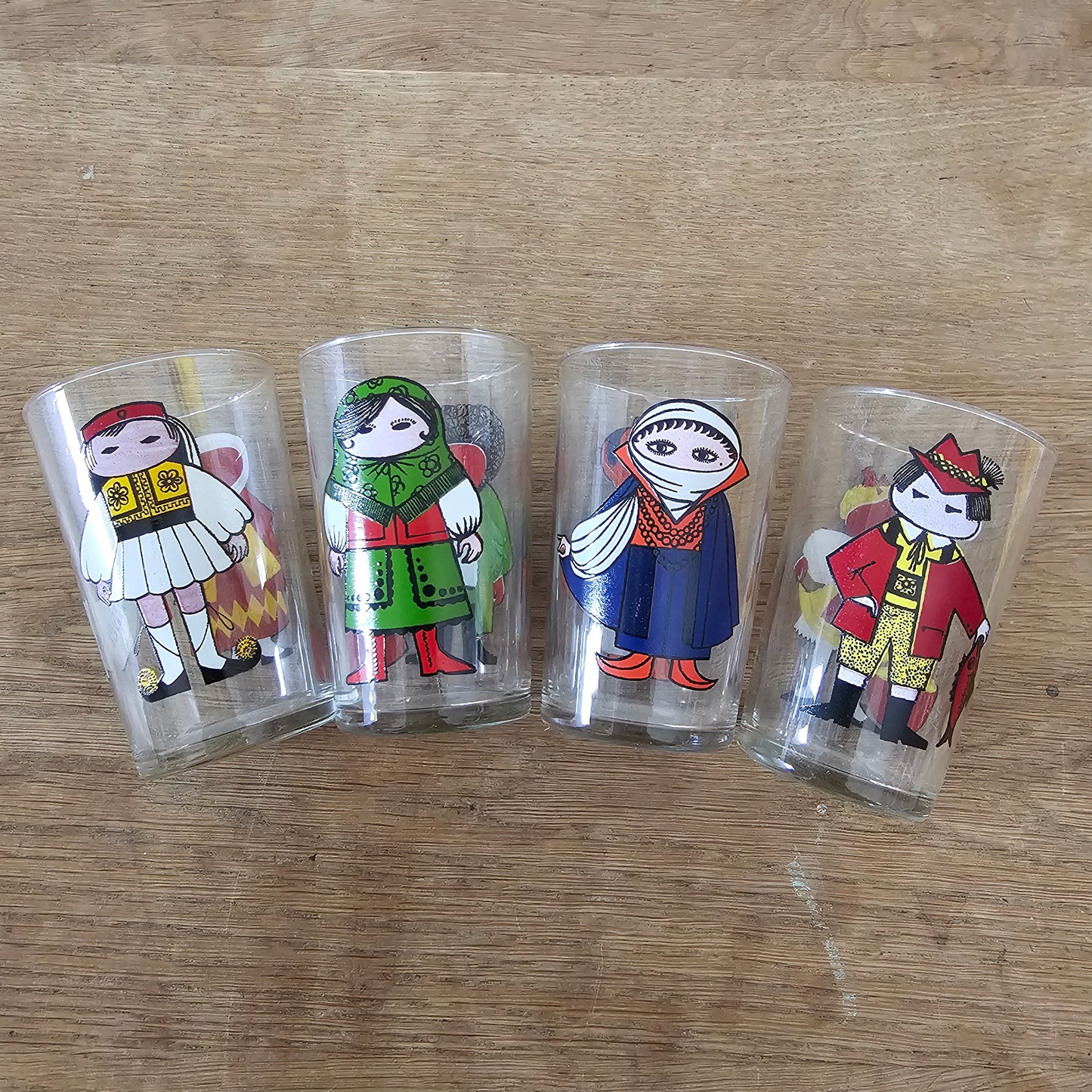 Set of four 1960s Saint-Gobain “World Doll” character tumblers with original box