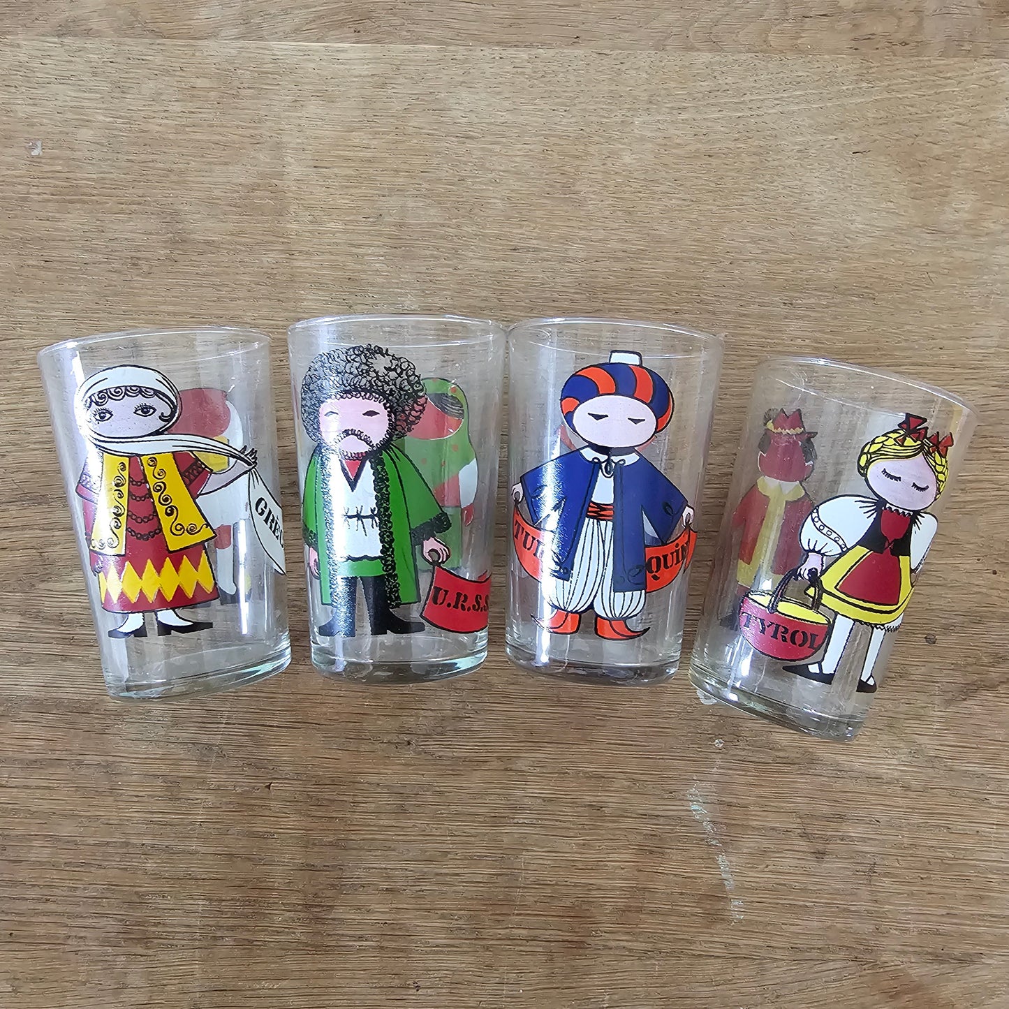Set of four 1960s Saint-Gobain “World Doll” character tumblers with original box