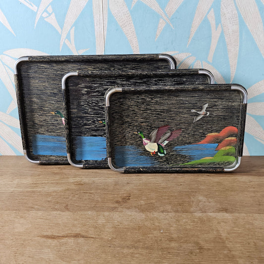 Set of three 1950s hand-painted black serving trays with flying duck detail