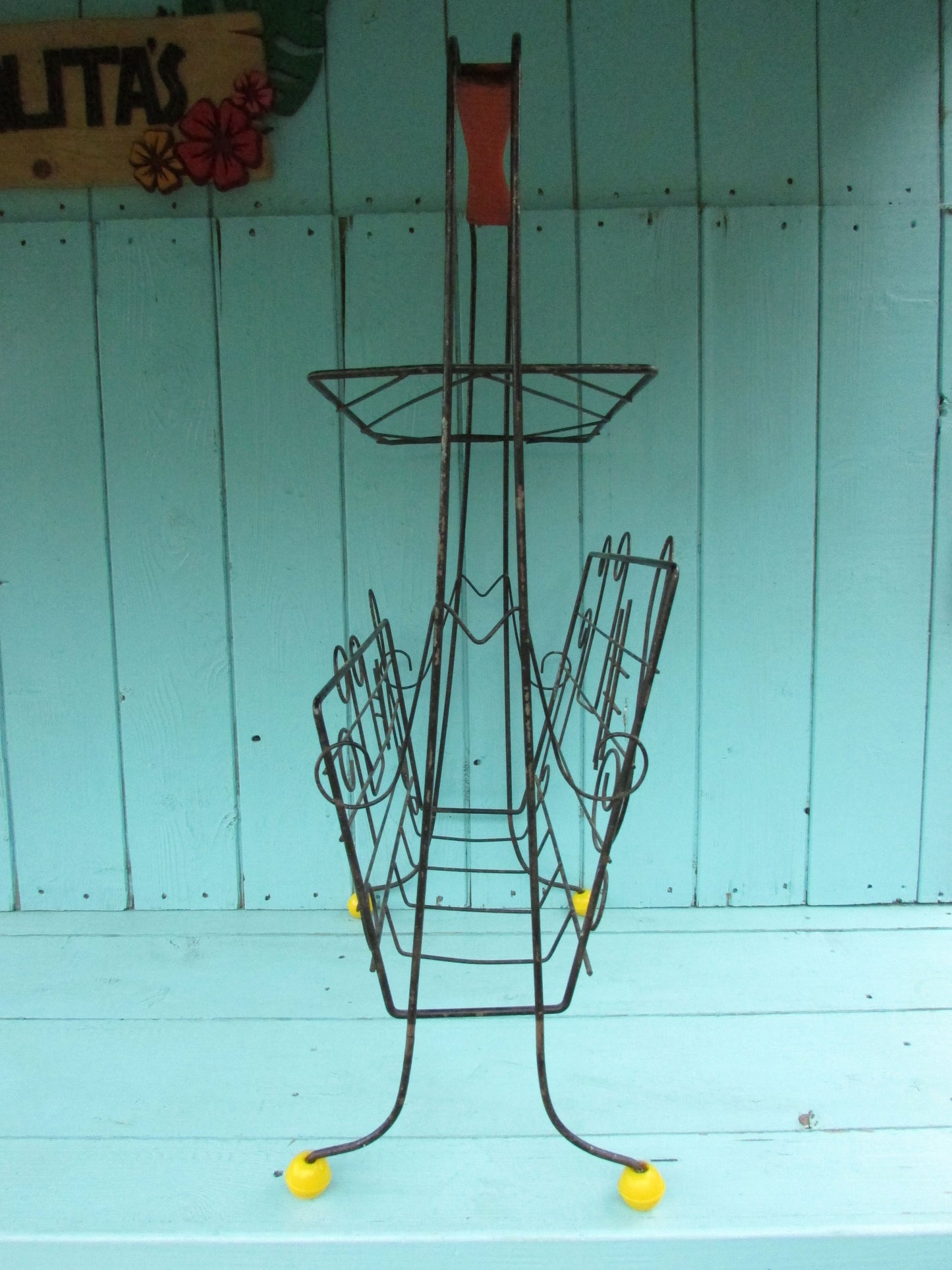 Mid-century metal atomic music note magazine rack with woven handle and ball feet detail