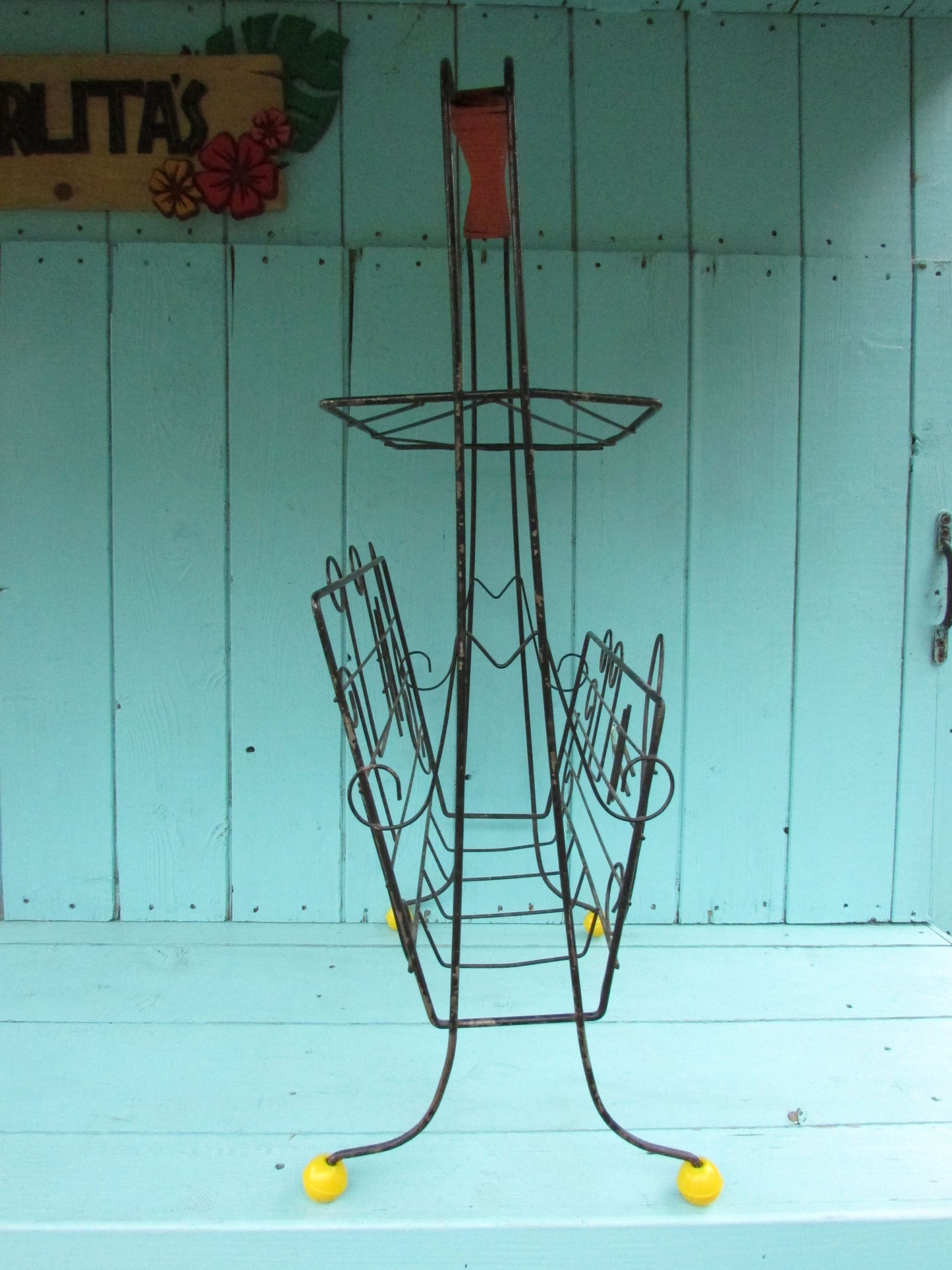 Mid-century metal atomic music note magazine rack with woven handle and ball feet detail