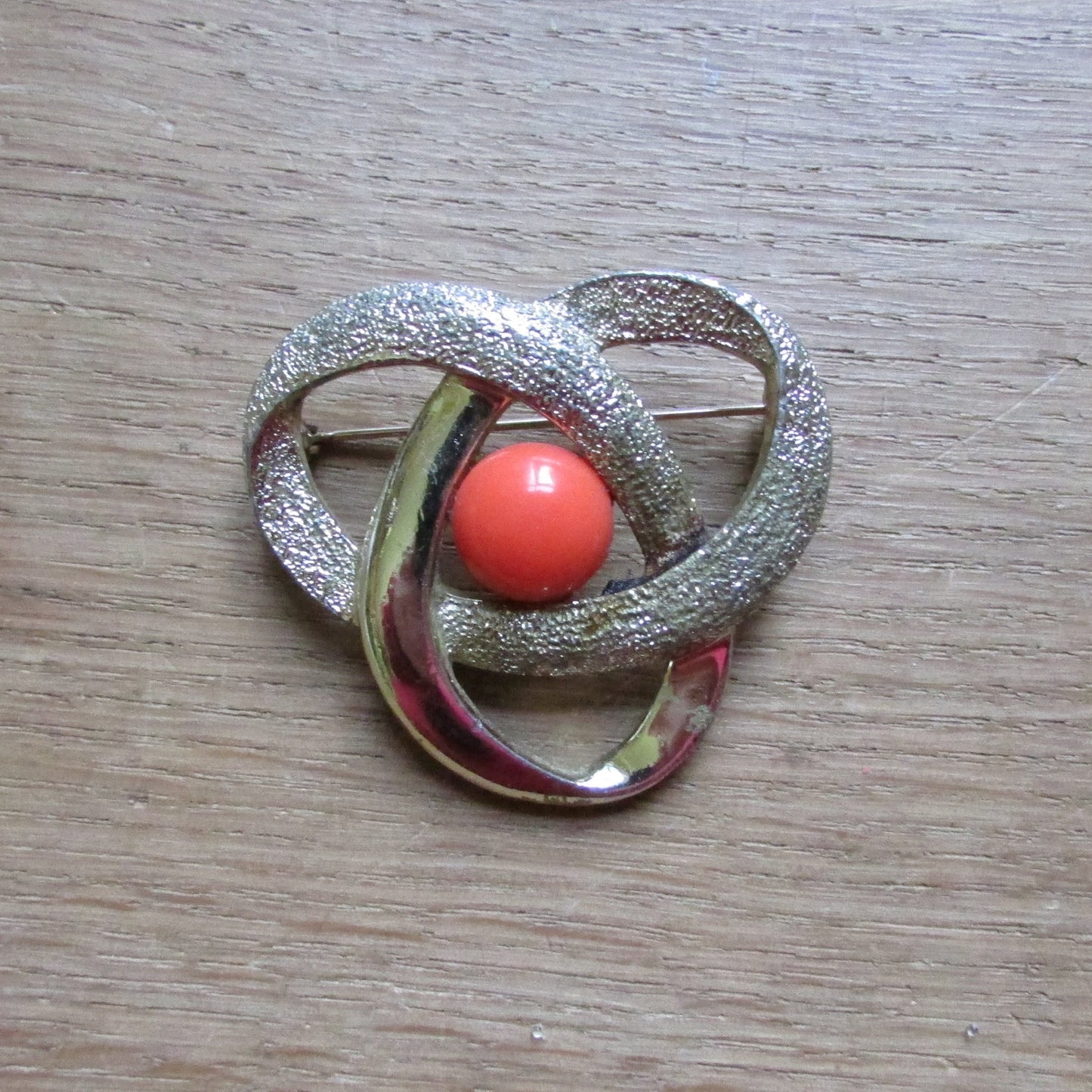 Vintage Sarah Coventry gold-tone twist brooch with tangerine cabochon centre