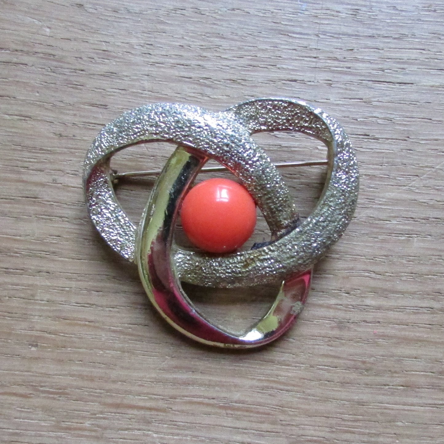 Vintage Sarah Coventry gold-tone orbit brooch with tangerine cabochon centre