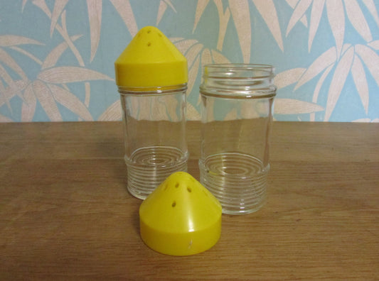 Pair of 1960s glass sugar pourers with yellow plastic lids
