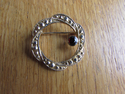 Vintage gold-tone ribbon swirl circlet brooch with garnet red diamanté detail