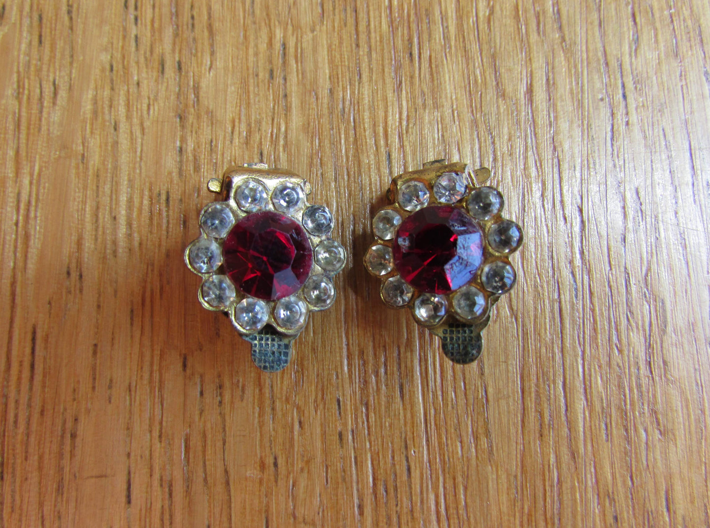 Small mid-century gold-tone clip on earrings with ruby red central glass surrounded by diamanté