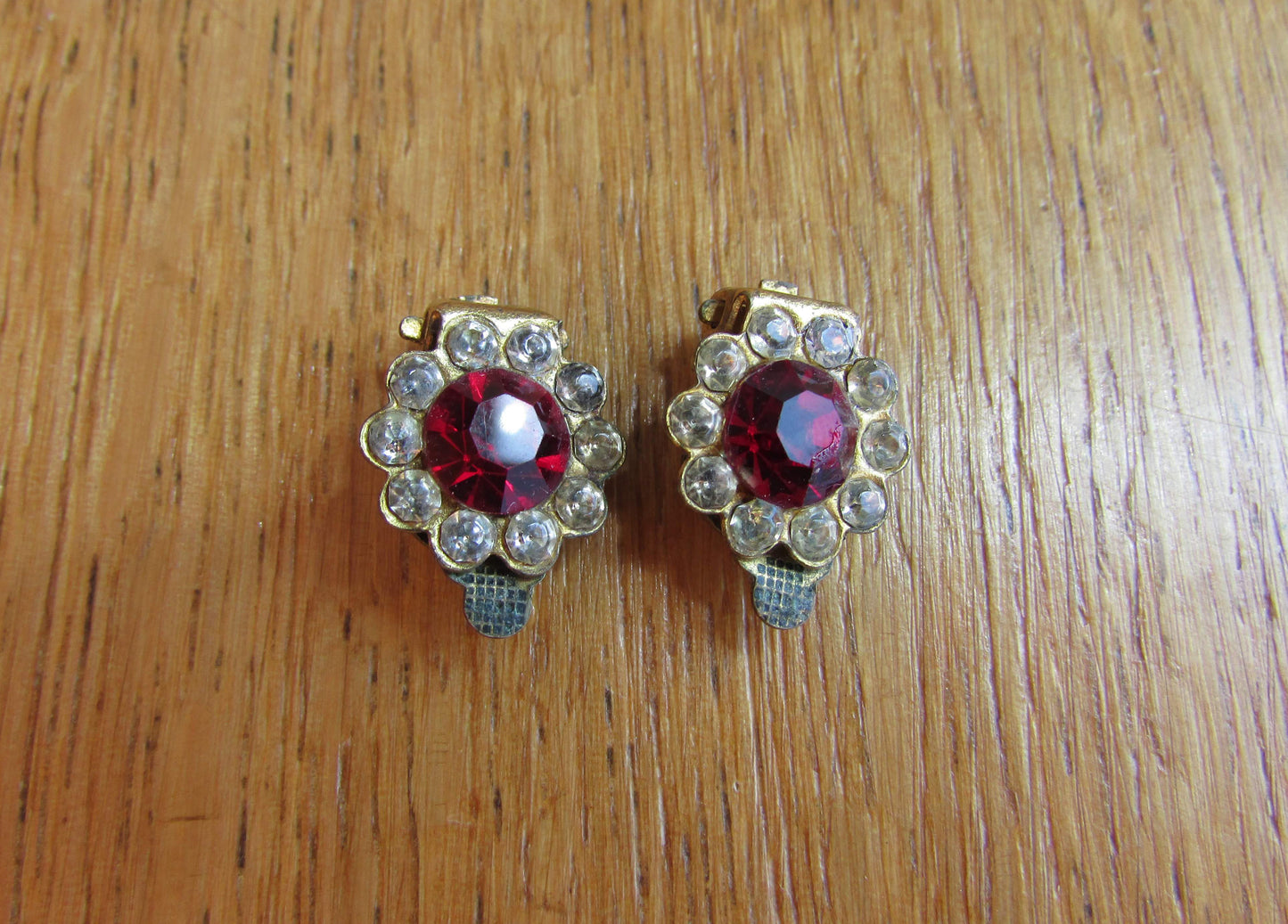 Small mid-century gold-tone clip on earrings with ruby red central glass surrounded by diamanté