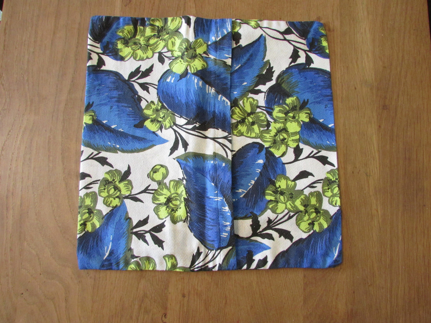 Home-made vintage bright blue leaf pattern cushion cover with same pattern reverse