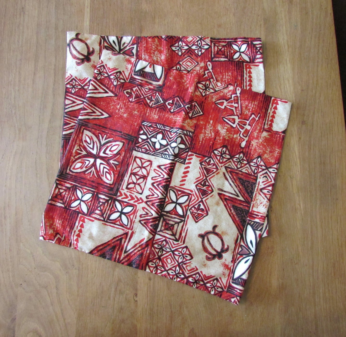 Home-made vintage red Hawaiian-style/tiki pattern cushion cover with same pattern reverse