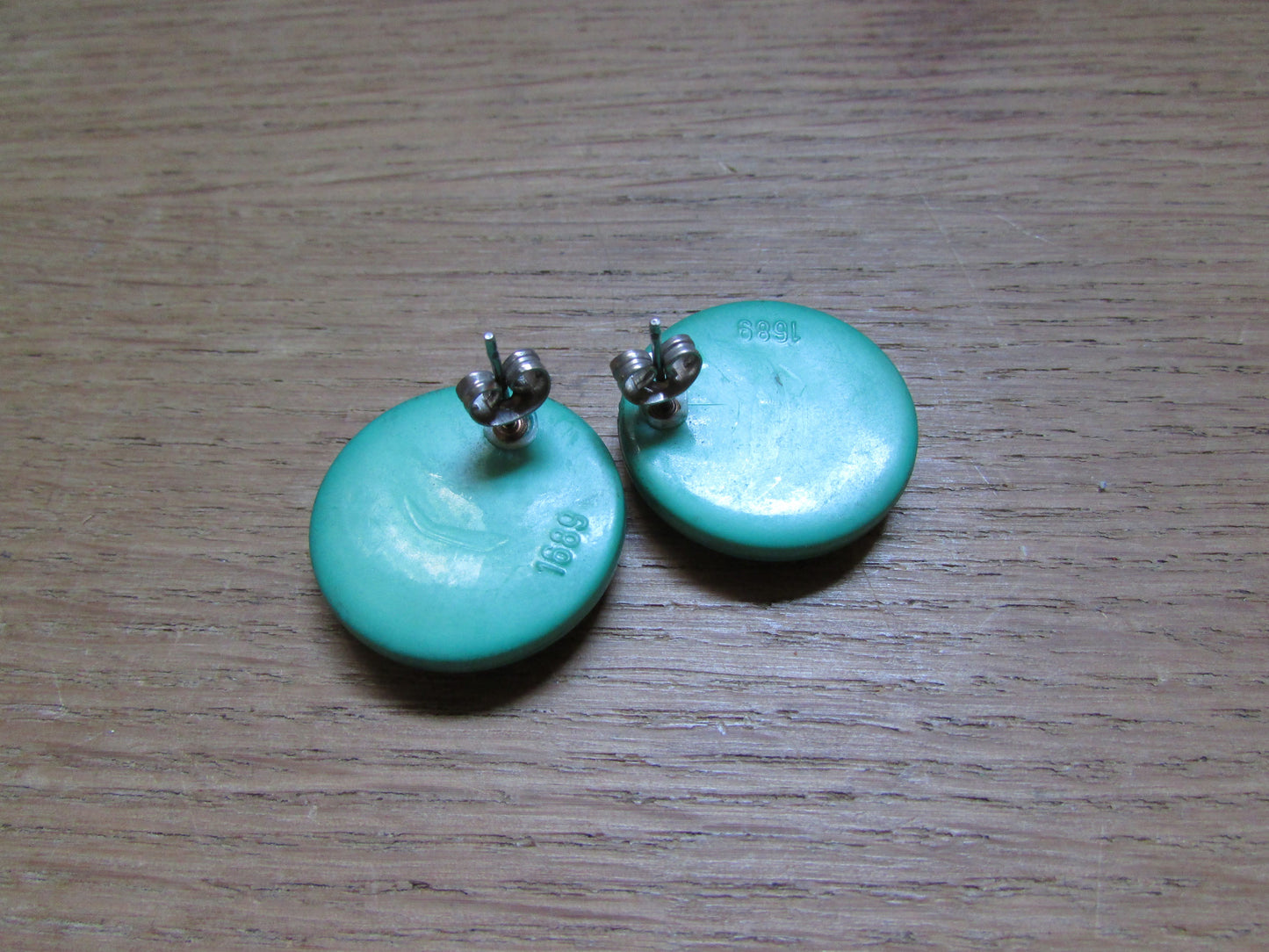 Large vintage round green plastic ridged earrings marked 1689