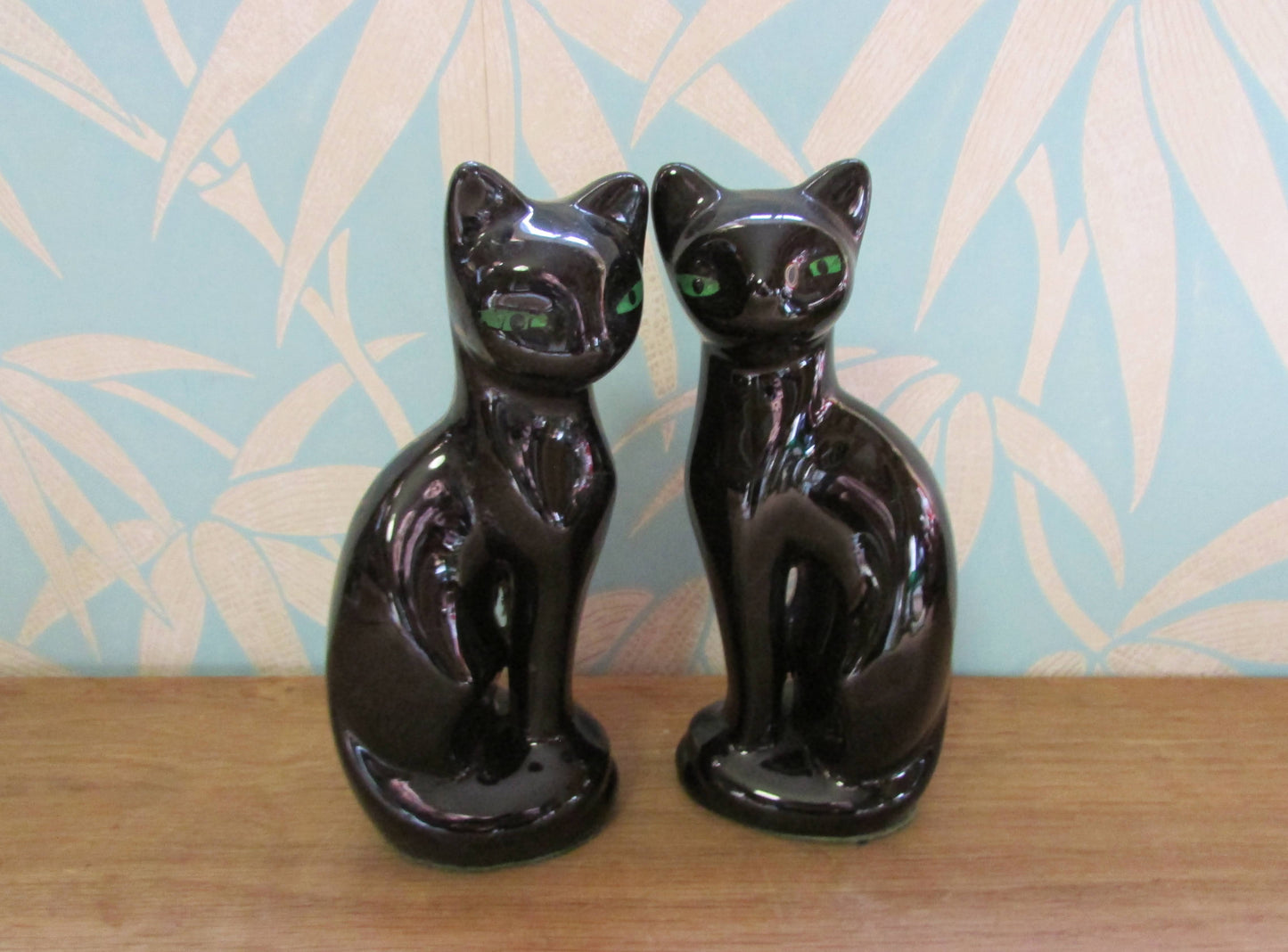 Pair of mid-century black ceramic mantel cats with green eyes
