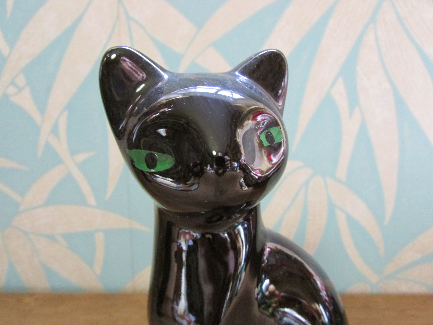 Pair of mid-century black ceramic mantel cats with green eyes