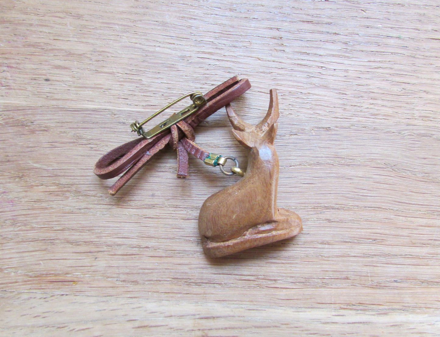 Vintage hand carved wooden sitting antelope brooch with leather bow