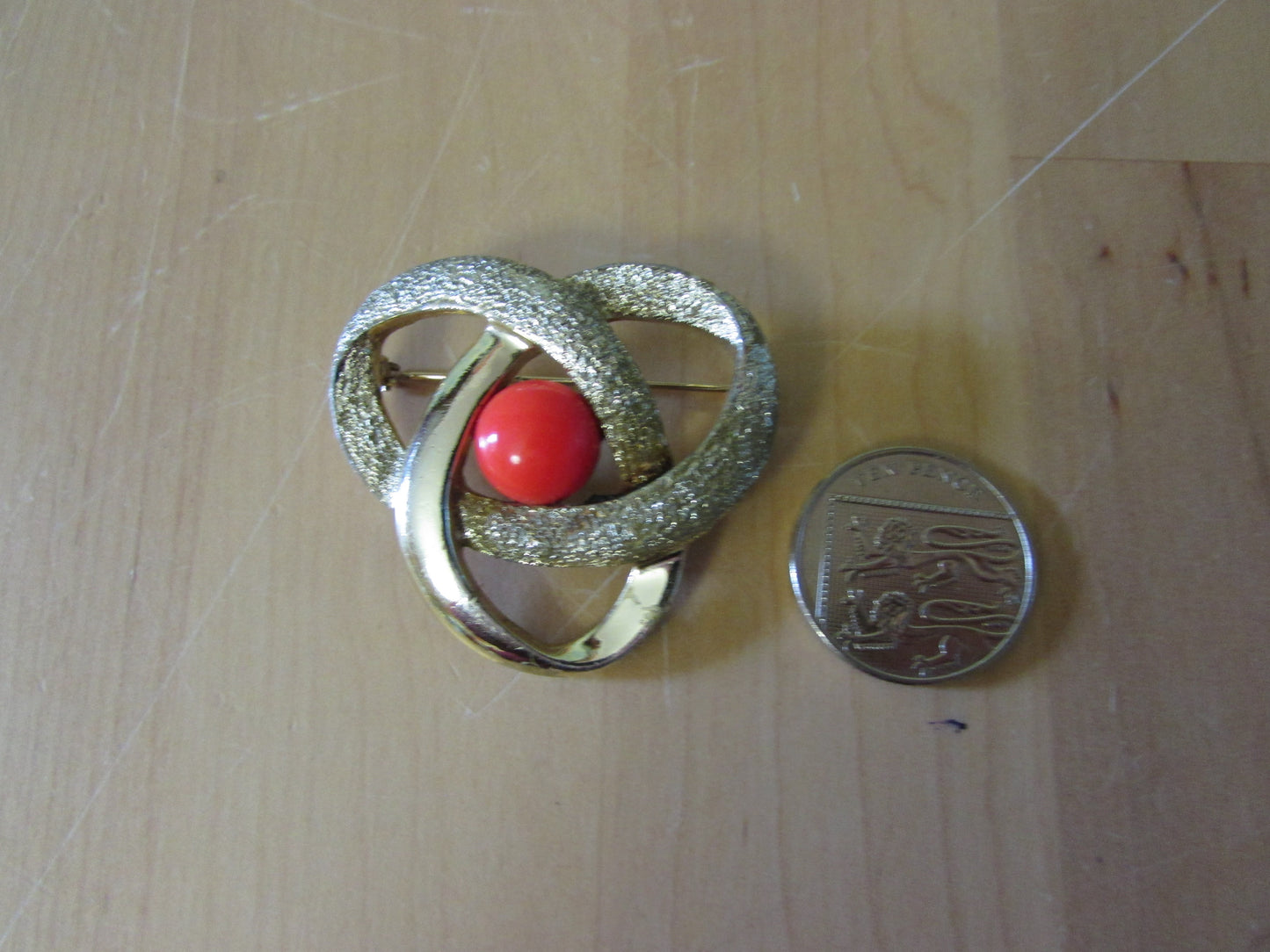 Vintage Sarah Coventry gold-tone twist brooch with tangerine cabochon centre