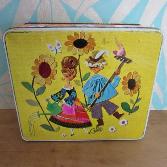 1960s/70s yellow & orange floral patterned tin, kitsch couple on lid watering sunflowers