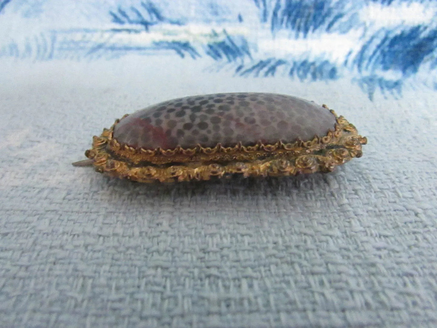 Antique polished coral stone lozenge shaped brooch/pendant in textured gold-tone surround