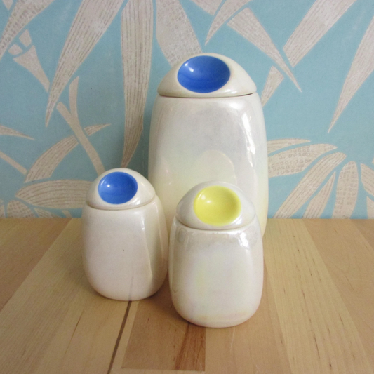 Three mid-century Romanian lustred ceramic storage caddies with contrast colour 'pinched' lids