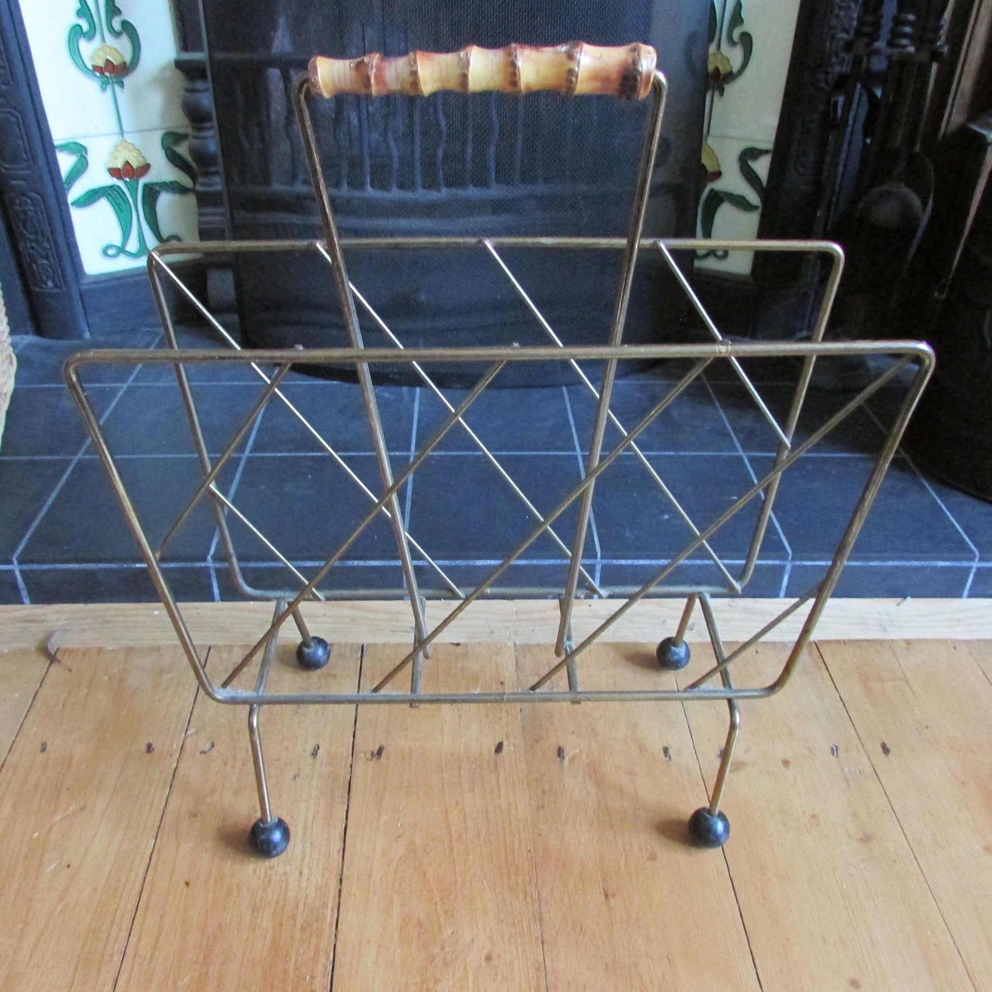Mid-century metal magazine rack with bamboo handle and ball feet