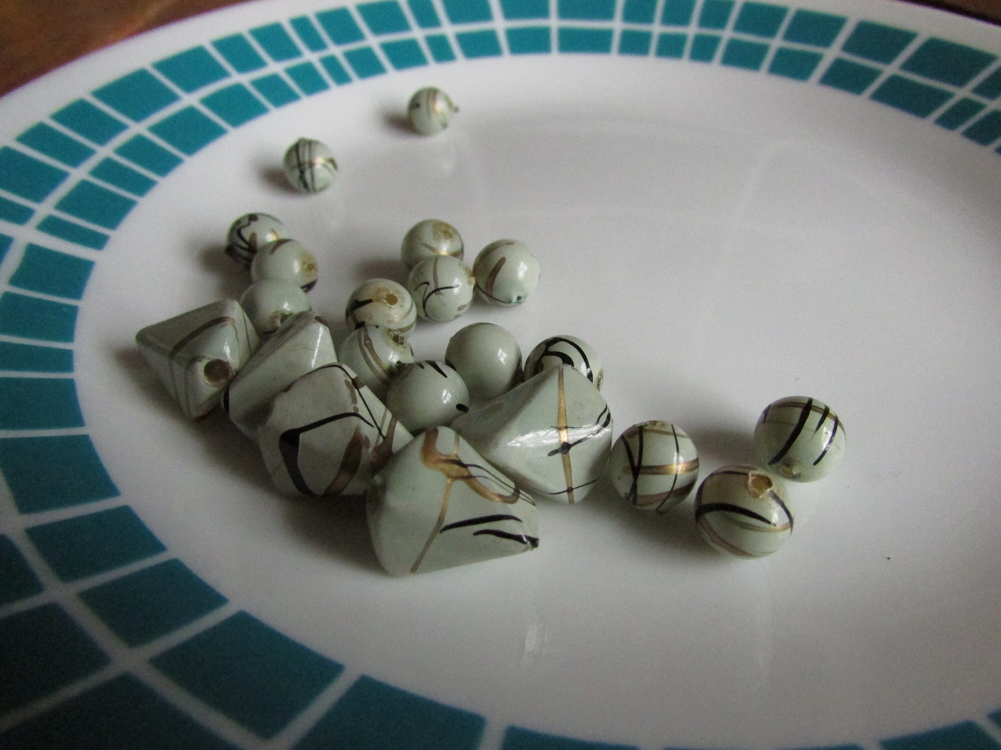 21 vintage pale grey with gold and black squiggles plastic beads