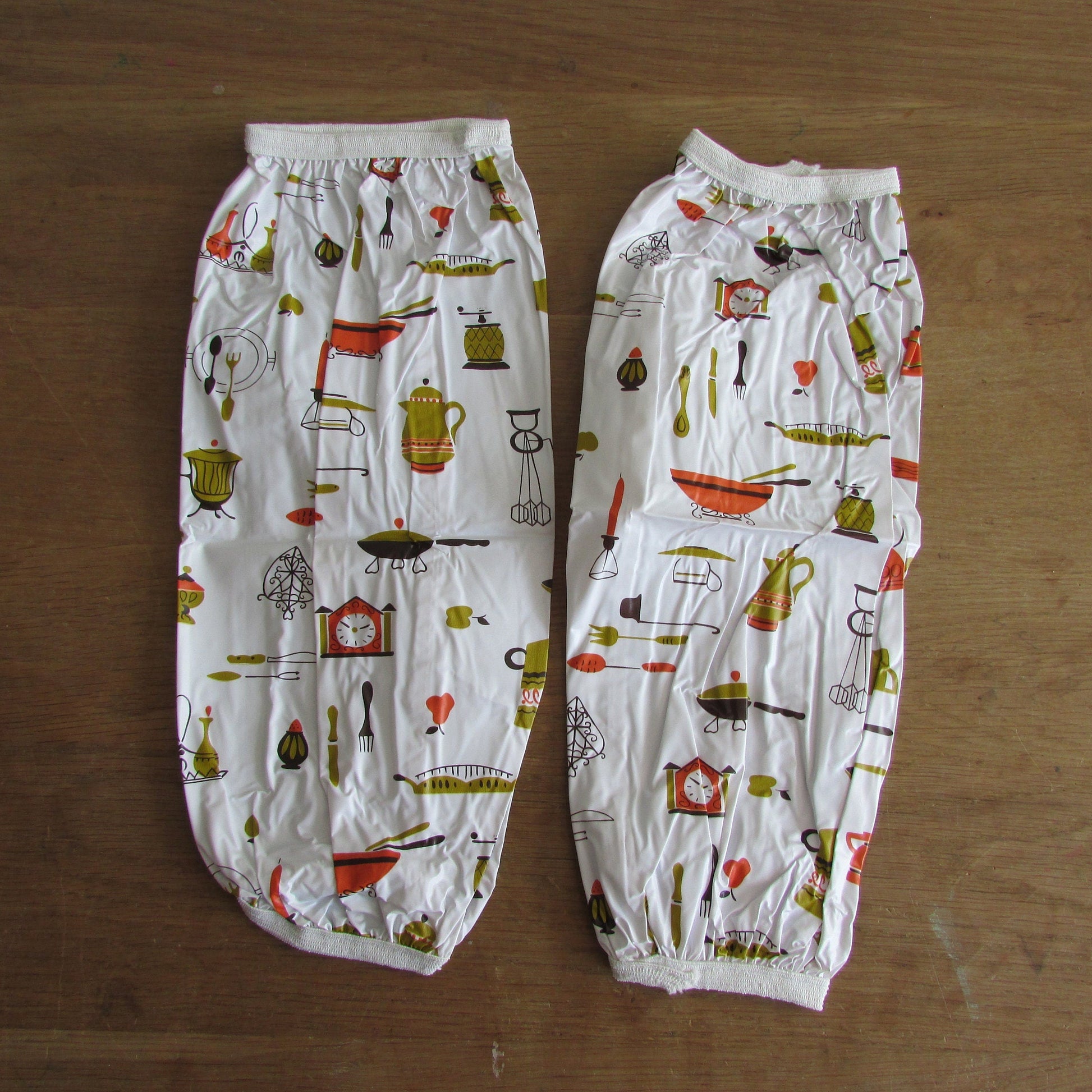 Pair of vintage Lakeland Plastics plastic sleeve protectors, 1950s style kitchen appliances/utensil print
