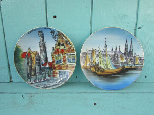 Two vintage decorative hand-painted wall plates depicting scenes from The Rozenhoedkaai in Brugge