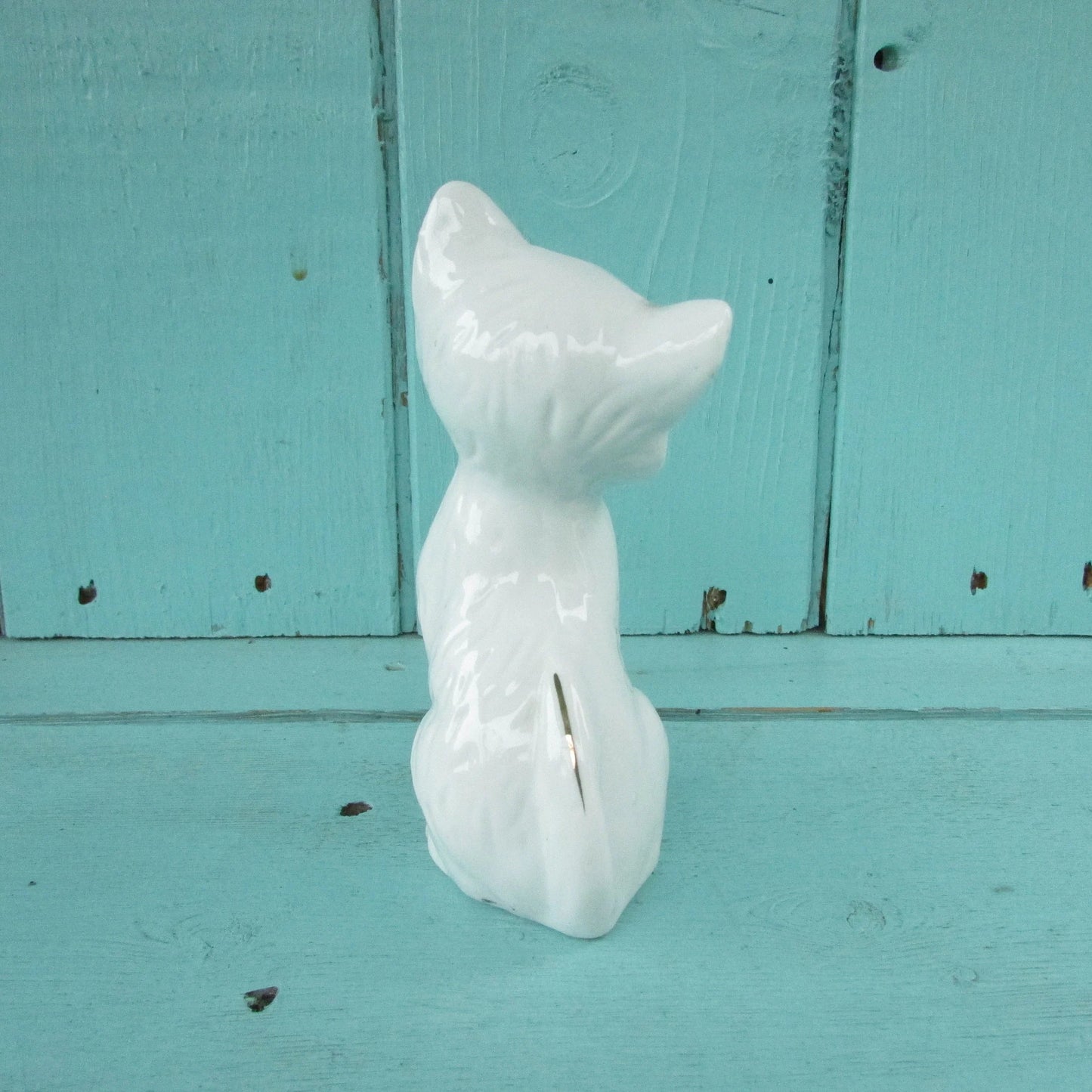 circa. 1960s kitsch white kitten ornament with blue bow detail