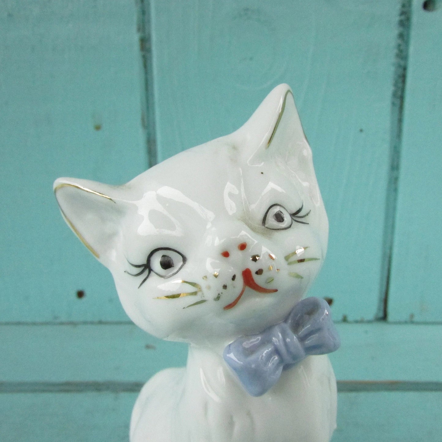 circa. 1960s kitsch white kitten ornament with blue bow detail