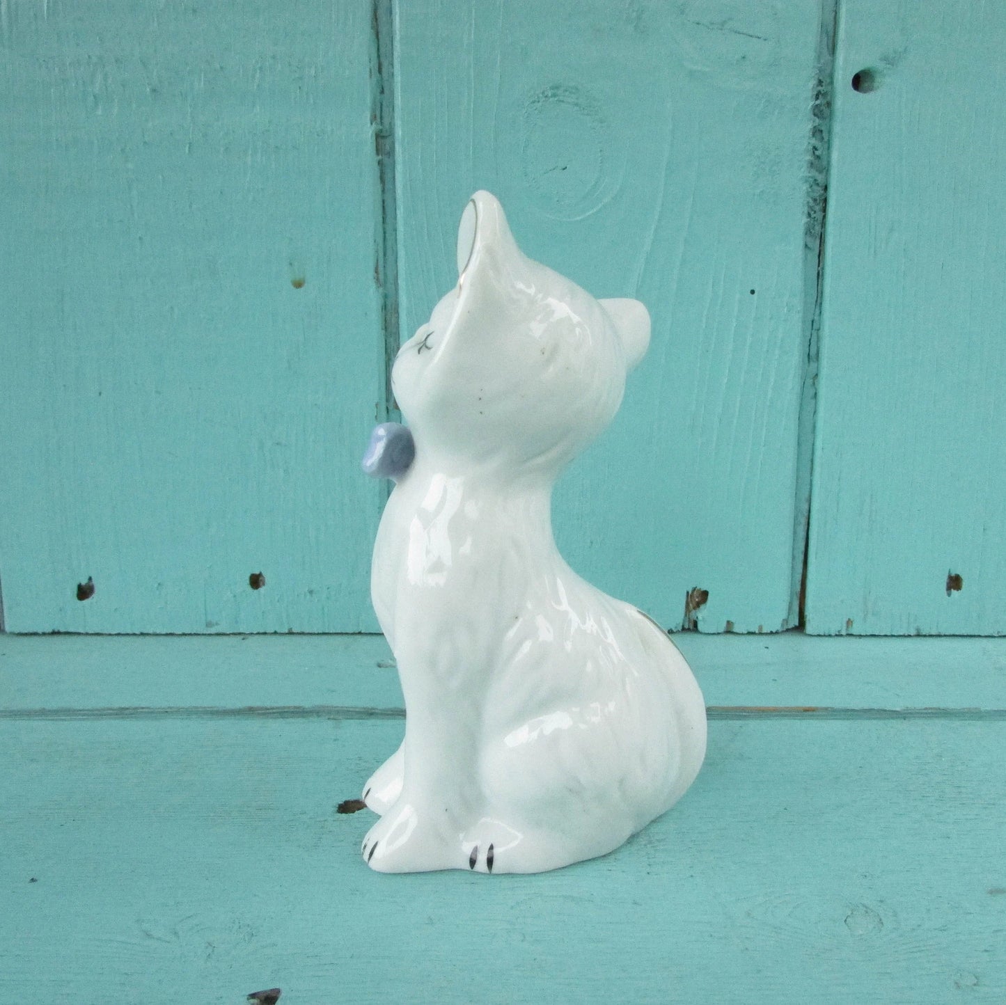 circa. 1960s kitsch white kitten ornament with blue bow detail
