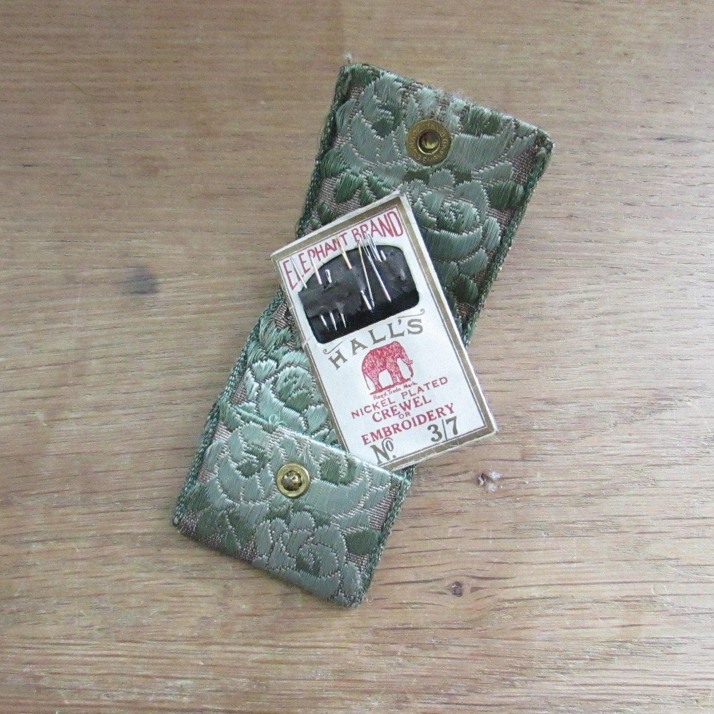 Vintage fabric needle case containing Elephant Brand Hall's nickel plated crewel or embroidery needles No.317