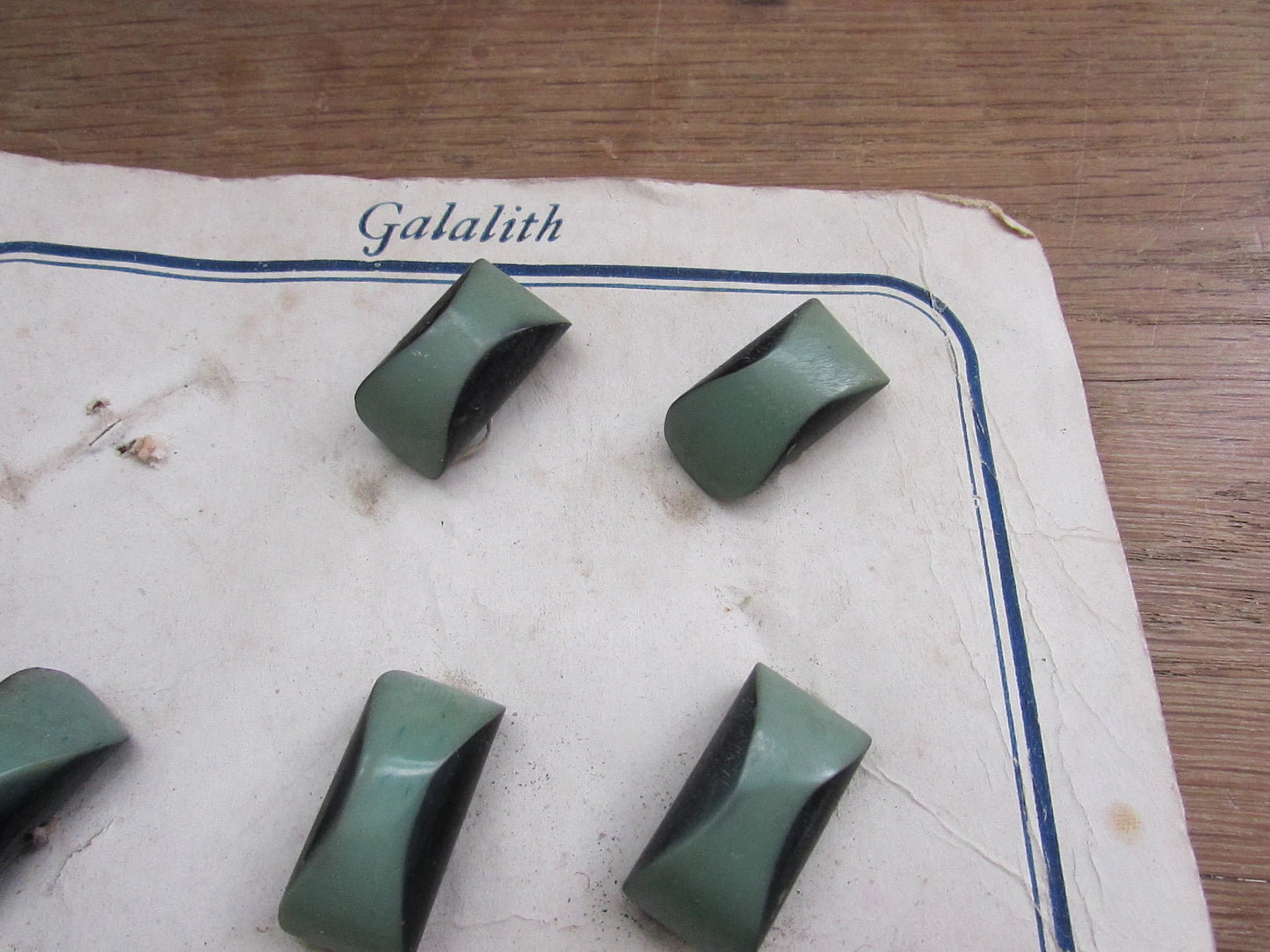1930s Galalith carded two-tone green domed oblong buttons x11