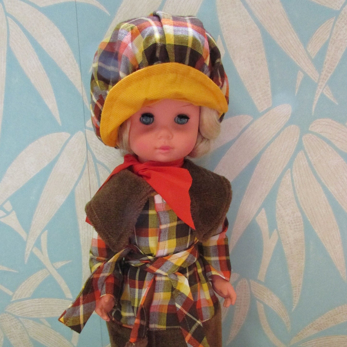 1970s plastic sleepy eye doll in cool tartan coat and matching hat
