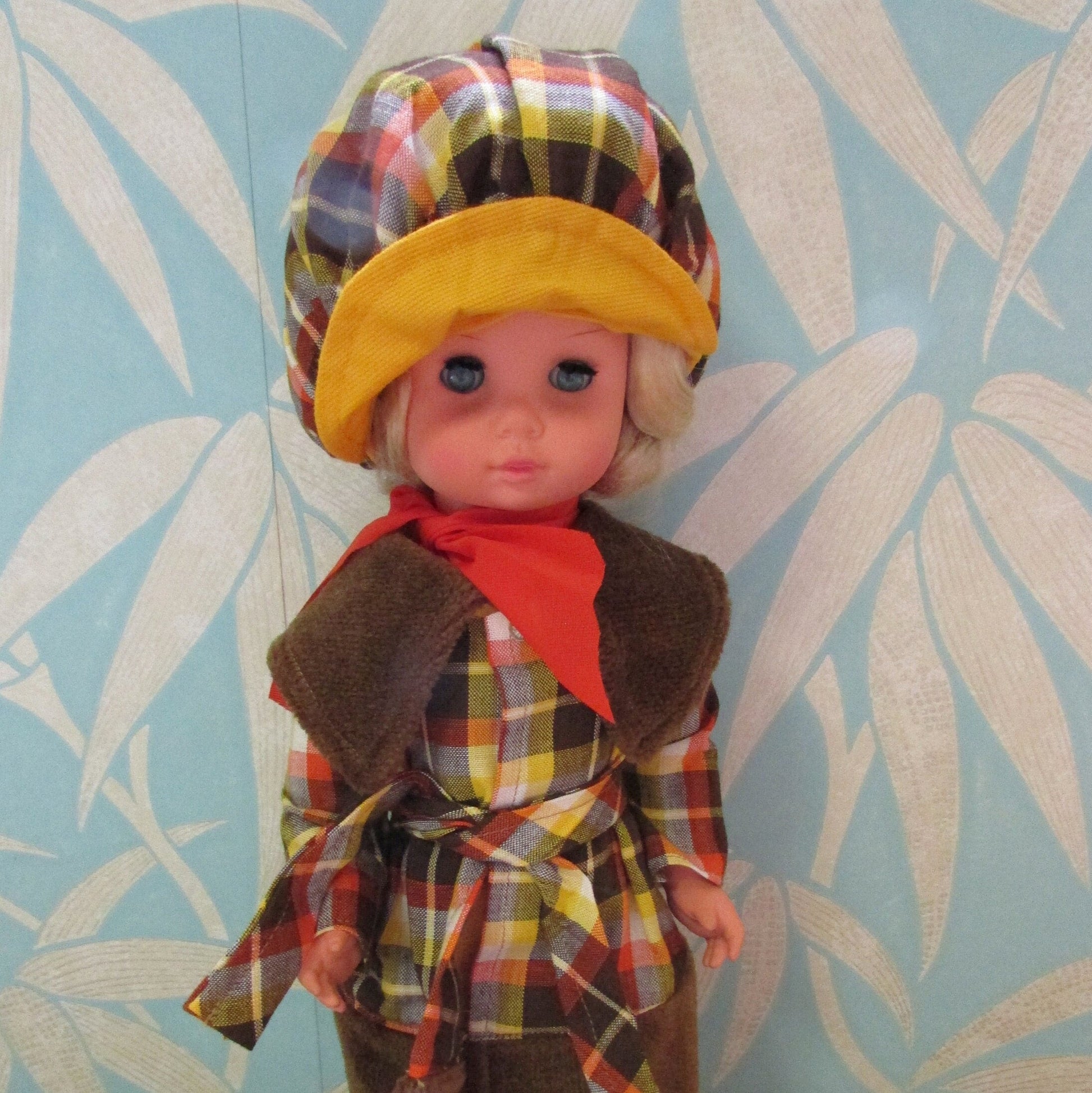 1970s plastic sleepy eye doll in cool tartan coat and matching hat