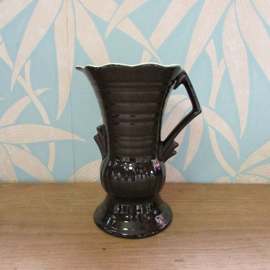Vintage Art Deco-style black ribbed ceramic pitcher with yellow liner glaze