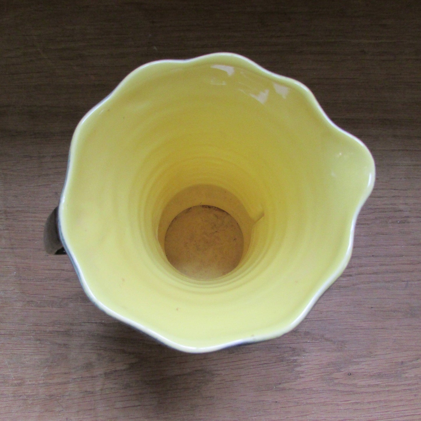 Vintage Art Deco-style black ribbed ceramic pitcher with yellow liner glaze