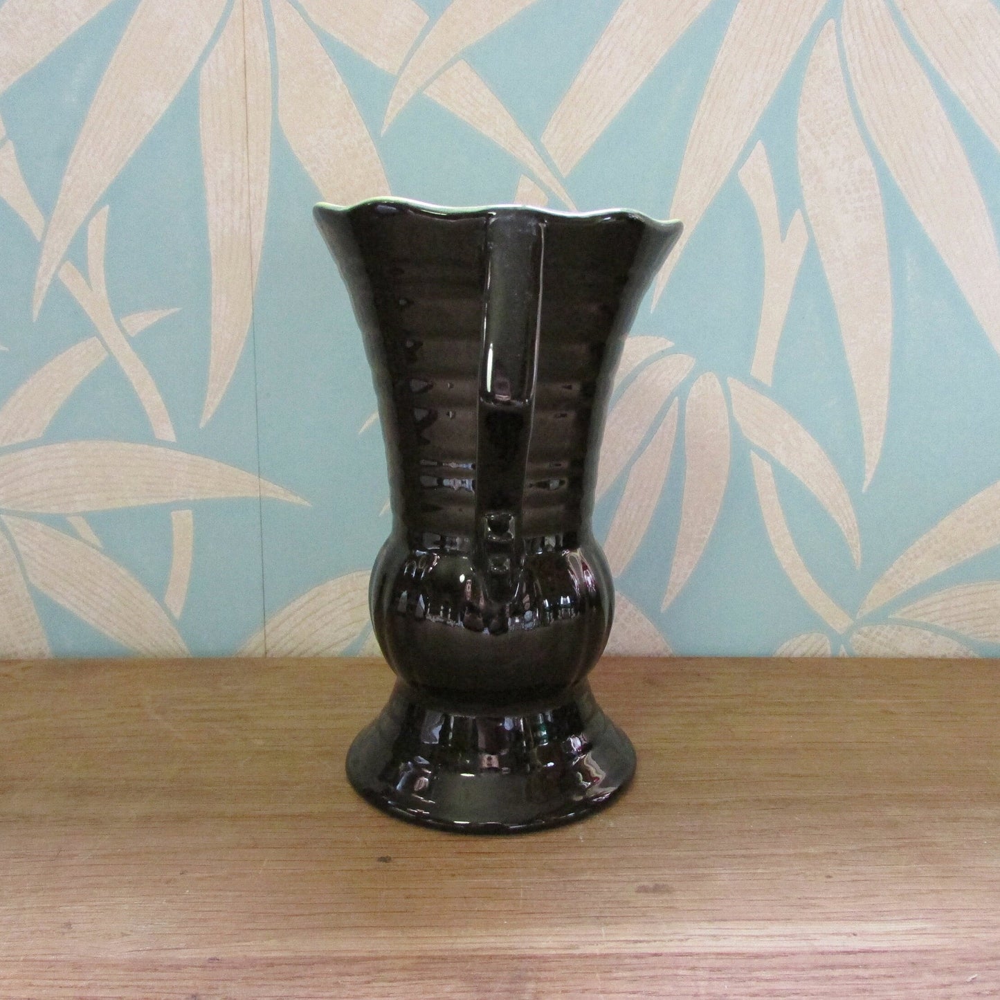 Vintage Art Deco-style black ribbed ceramic pitcher with yellow liner glaze