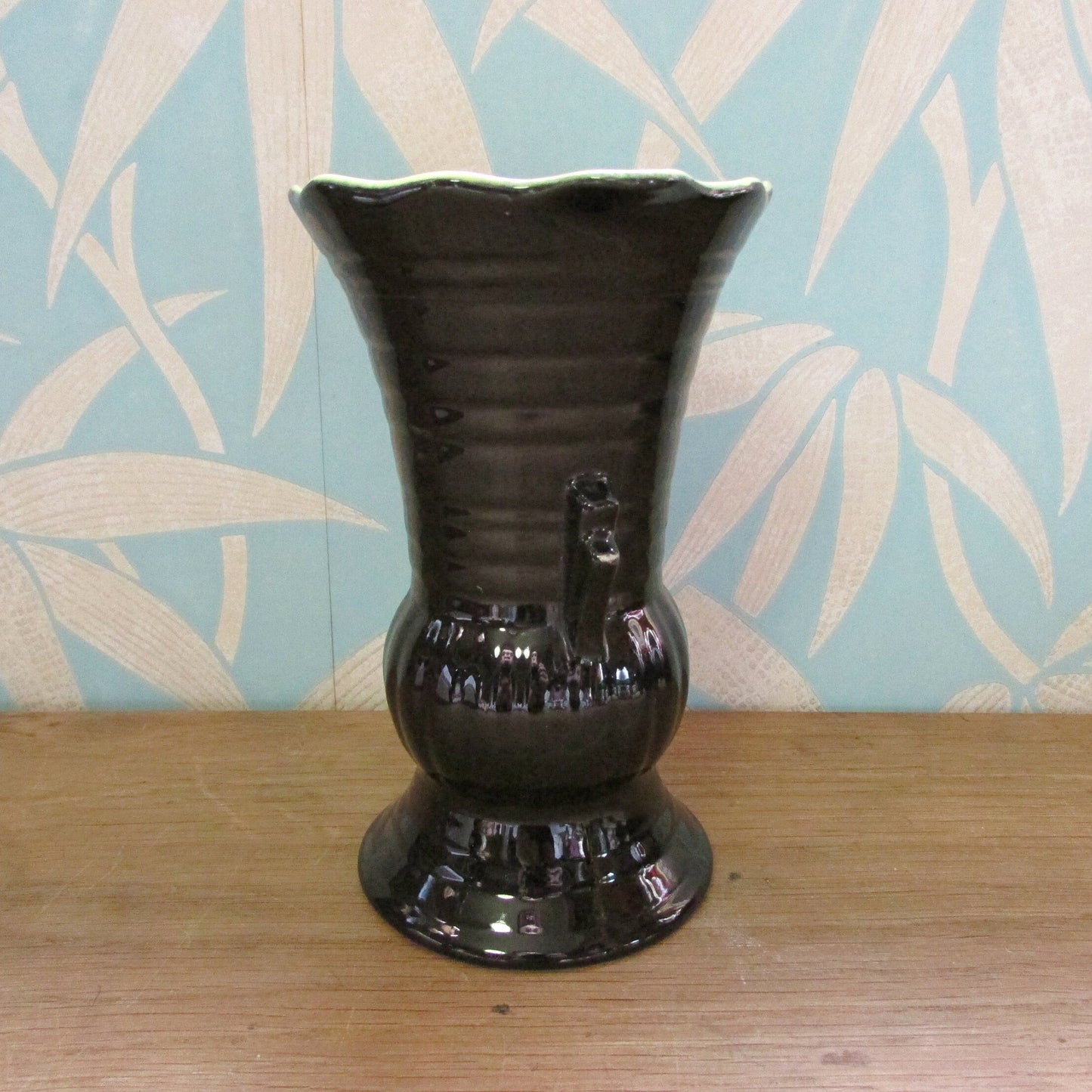 Vintage Art Deco-style black ribbed ceramic pitcher with yellow liner glaze