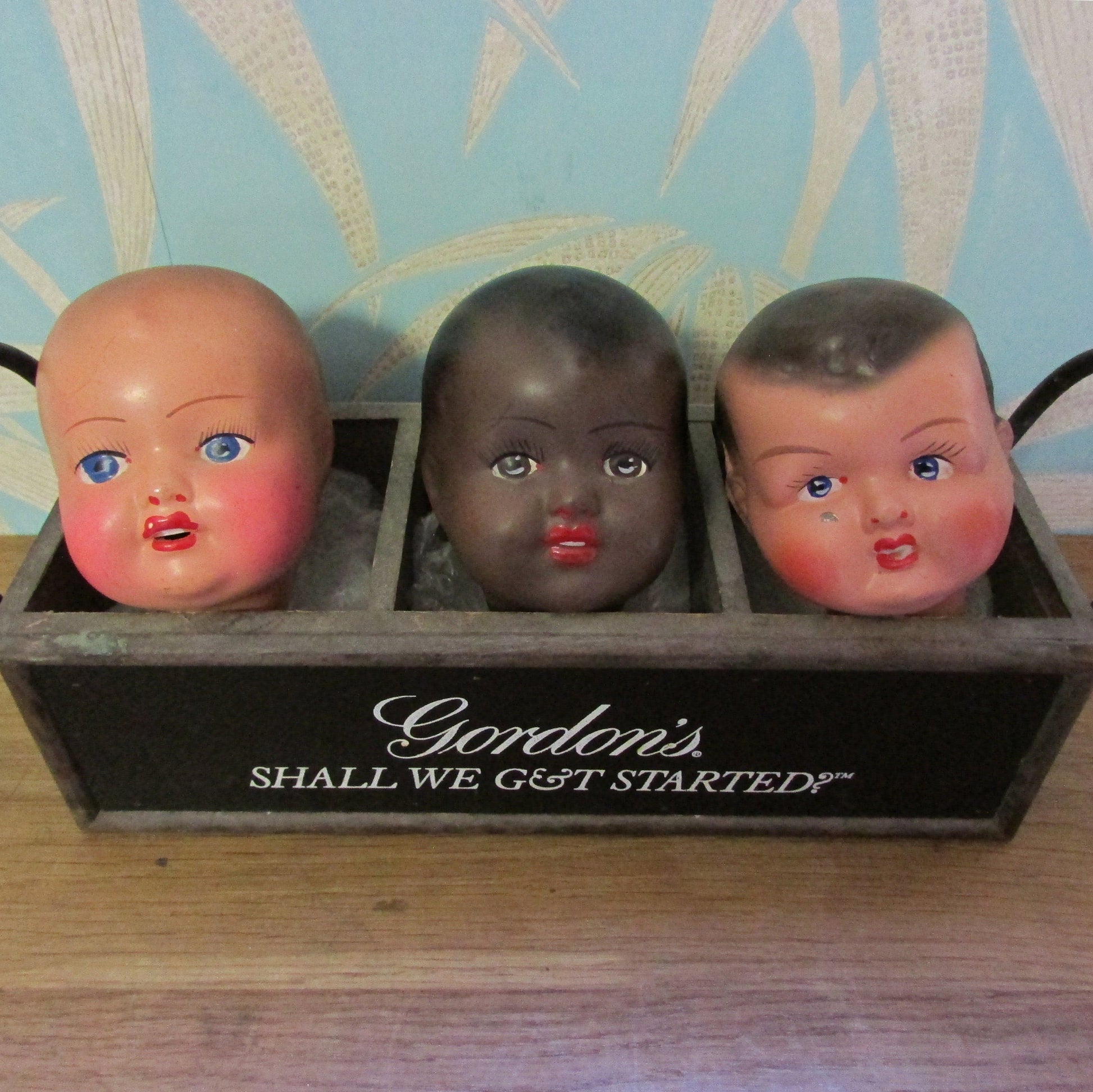 Three antique porcelain baby doll heads - with or without vintage bottle crate