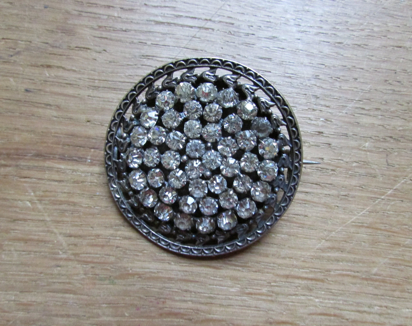 Early 20th century silver-metal diamanté fleur de lys detailed round brooch