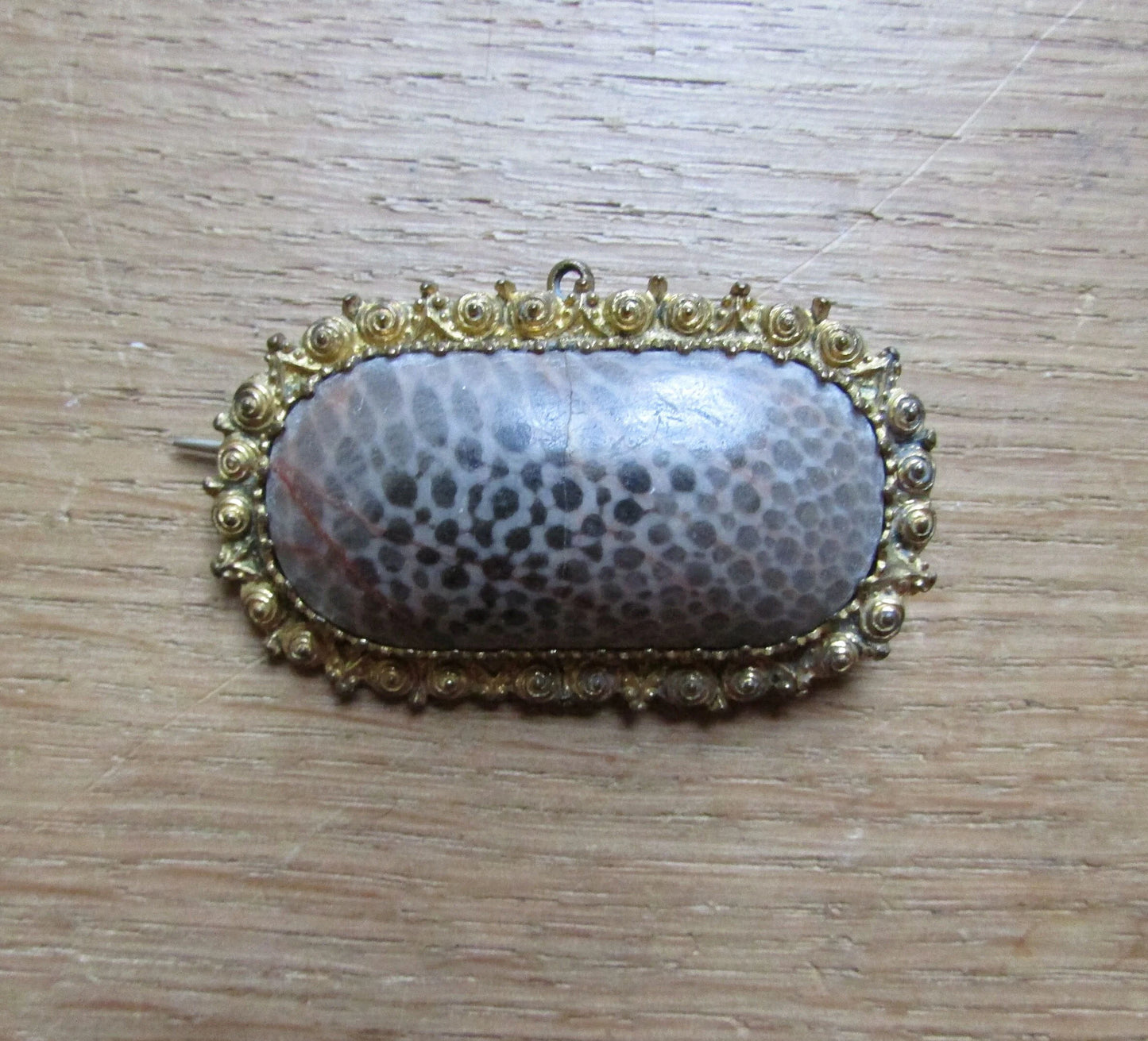 Antique polished coral stone lozenge shaped brooch/pendant in textured gold-tone surround