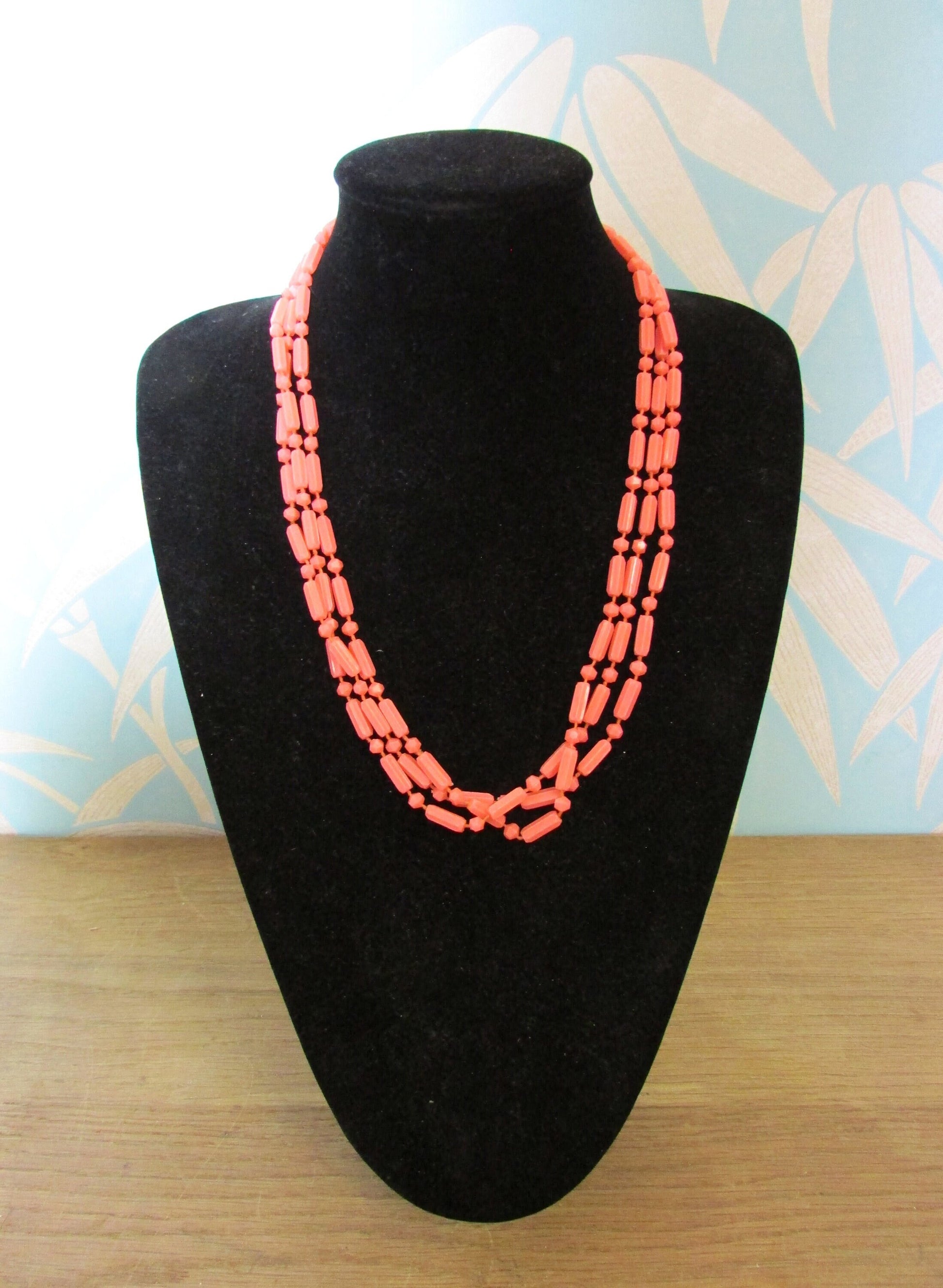 Mid-century fused plastic "dot n dash" coral bead triple strand necklace, silver-tone clasp detail