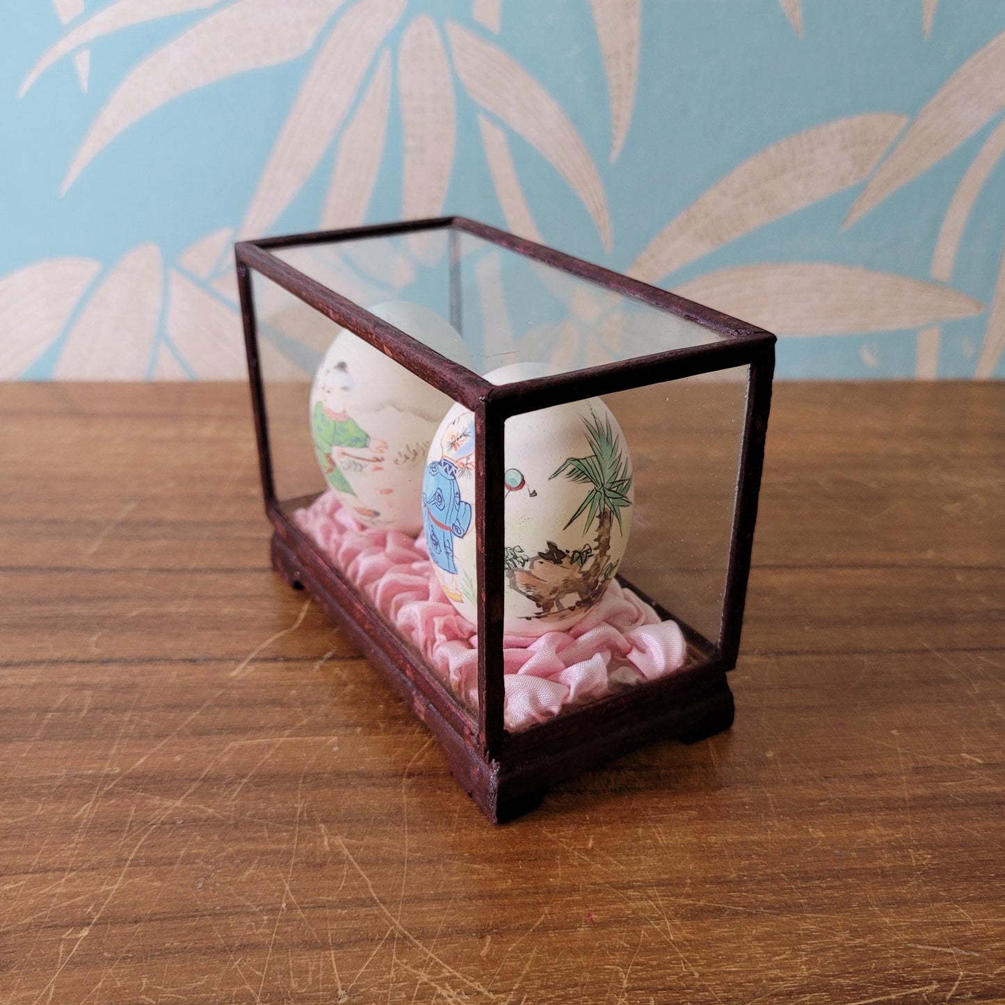 Pair of vintage Chinese hand-painted eggshells in glass display case, children playing