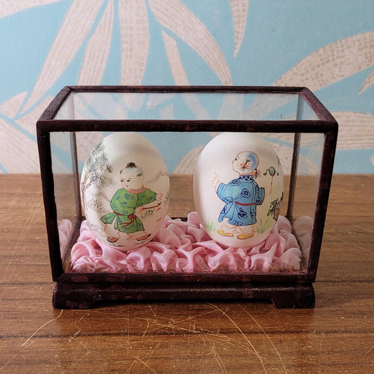 Pair of vintage Chinese hand-painted eggshells in glass display case, children playing