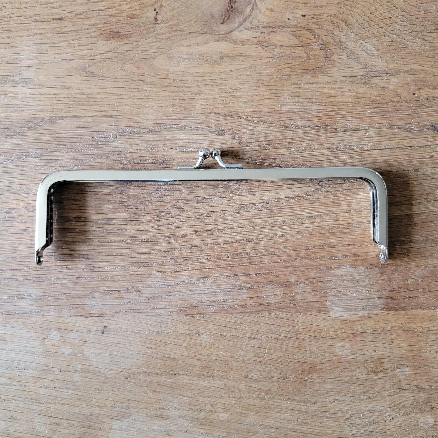 Silver-tone metal purse frame with kiss ball clasp