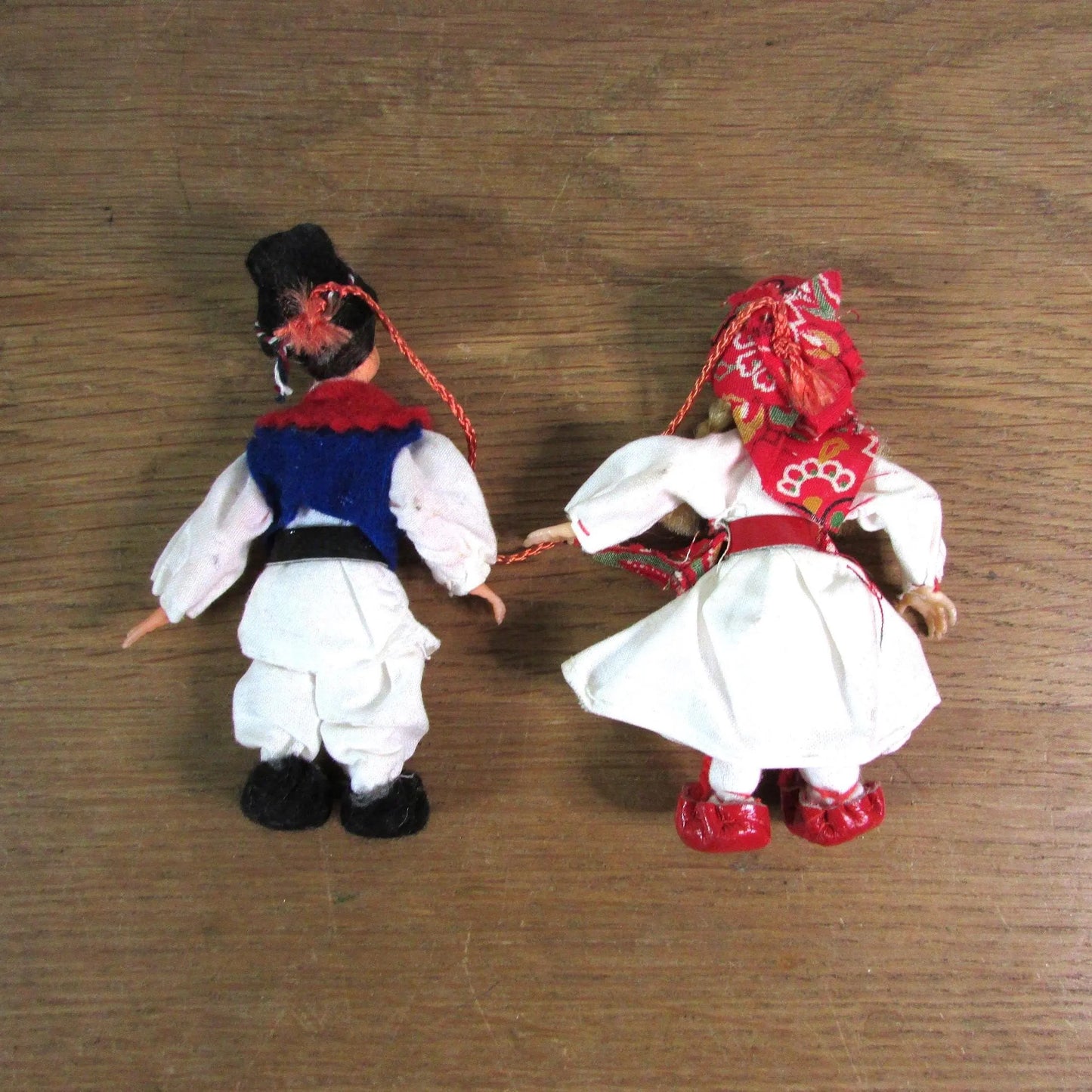 Pair of vintage miniature Yugoslavian souvenir dolls, linked together, in traditional costume