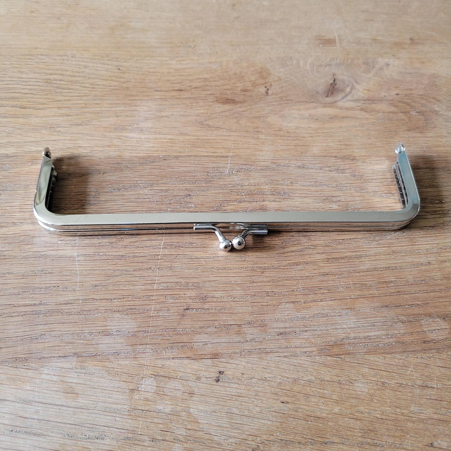 Silver-tone metal purse frame with kiss ball clasp
