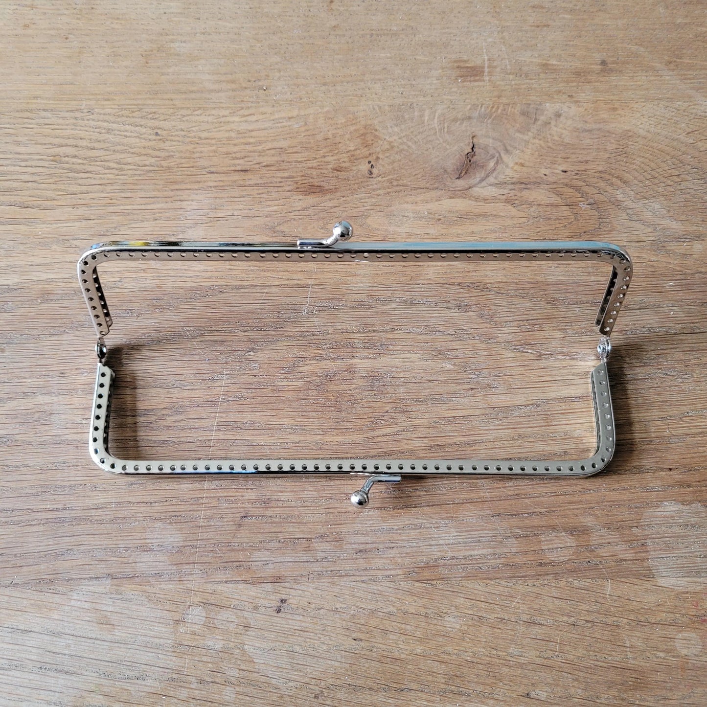 Silver-tone metal purse frame with kiss ball clasp